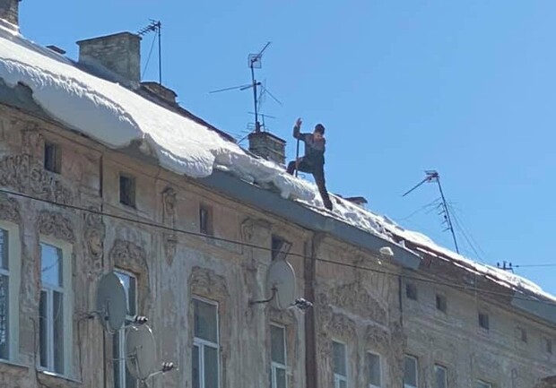 У Львові чоловік стояв на даху багатоповерхівки і лопатою скидав сніг на тротуар. Фото: Варта1
