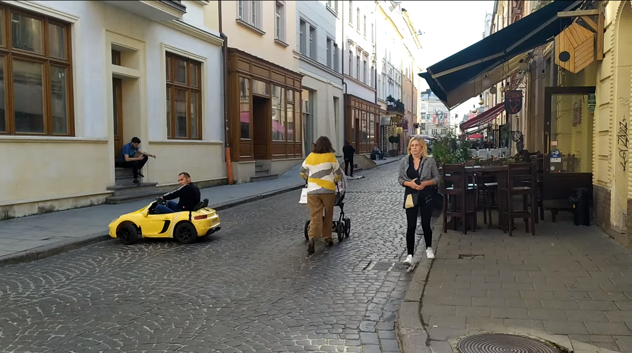 Туристи ганяють на дитячих машинках у центрі Львова. Скріншот з відео